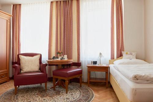 a bedroom with a bed and a chair and a table at Hametner mit Innviertlerhaus mit Thermenzugang in Bad Hall
