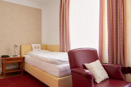 a hotel room with a bed and a chair at Hametner mit Innviertlerhaus mit Thermenzugang in Bad Hall