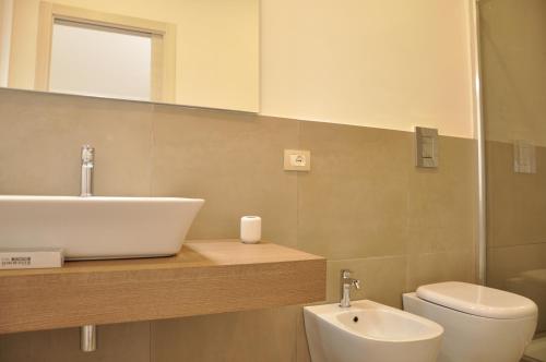 a bathroom with a sink and a toilet and a mirror at Anaka sweet home in Agrigento