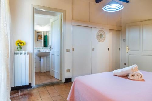a bedroom with a white bed and a bathroom at Agriturismo La Concia in Gavorrano