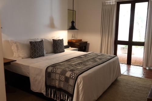 una camera da letto con un letto grande con una finestra di Geoffrey Bawa's Home Number 11 a Colombo