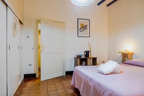a bedroom with a white bed and a white door at Agriturismo La Concia in Gavorrano