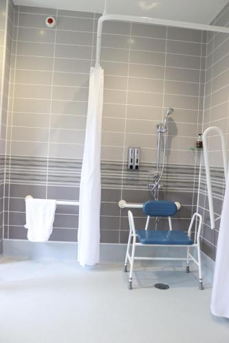 a bathroom with a chair and a shower at Gwesty Seren Hotel in Blaenau-Ffestiniog