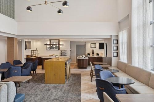 a lobby with tables and chairs and a living room at Staybridge Suites Sacramento Woodland by IHG in Woodland