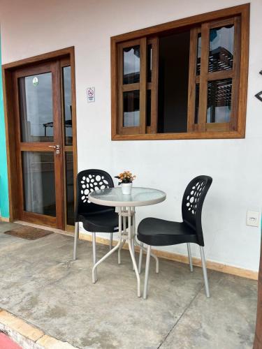 a table and two chairs sitting next to a building at Pousada Bugaendrus in Touros