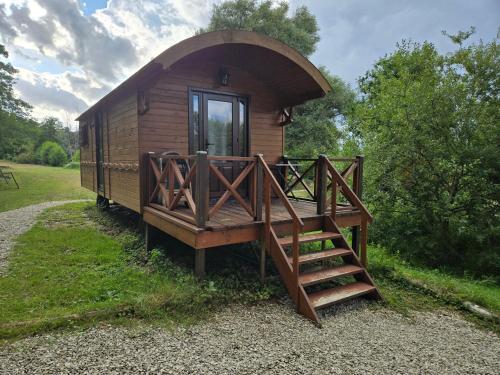 a small wooden cabin with a porch and a staircase at B&B Le Danica in Dordives
