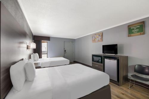 a hotel room with a large bed and a television at Econo Lodge Austin North near The Domain in Austin