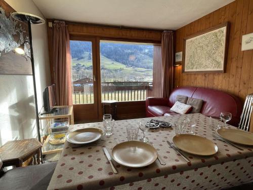 une table de salle à manger avec des assiettes et des verres dessus dans l'établissement Charmant 2P cabine 35m², proche pistes et village, parking, 4 pers. - FR-1-603-71, à Praz-sur-Arly