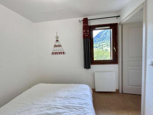 une chambre avec un lit blanc et une fenêtre dans l'établissement Appartement cosy à Flumet, pieds des pistes, 4 pers., piscine, parking, minibox Wifi. - FR-1-603-75, à Flumet
