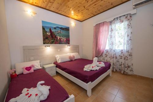 a bedroom with two beds and a window at Villa Eleni Holidays Resort up to 18 guests in Karousádes