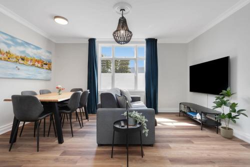 a living room with a table and chairs and a tv at Berg Apartments in Reykjavík