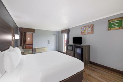 a large white bed in a hotel room at Econo Lodge Austin North near The Domain in Austin