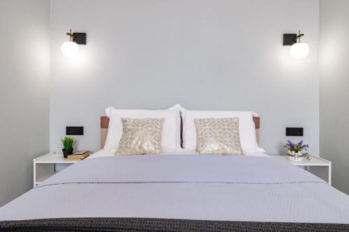 a white bedroom with a large bed with pillows at Bukhar Jyrau Modern Home in Astana