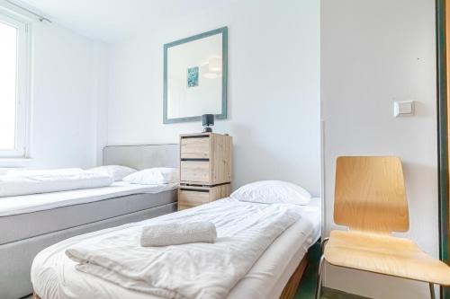 a room with two beds and a chair and a mirror at Hotel Astral Vienna in Vienna