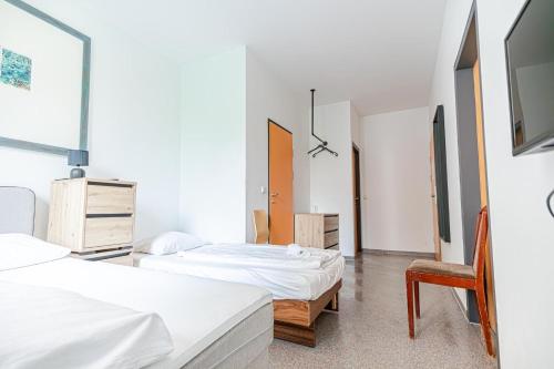 a bedroom with two beds and a chair at Hotel Astral Vienna in Vienna