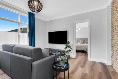 a living room with a couch and a tv at Berg Apartments in Reykjavík
