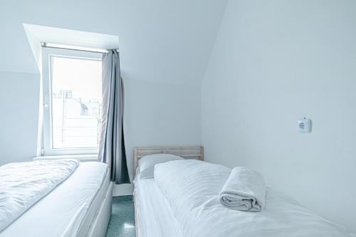 two beds in a room with a window at Hotel Astral Vienna in Vienna