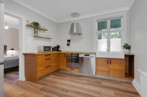 a kitchen with white walls and wooden cabinets at Berg Apartments in Reykjavík