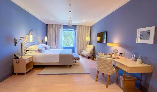 a blue bedroom with a bed and a desk and a desk at Hotel Supetar in Cavtat