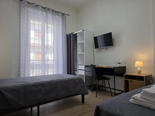 a bedroom with a bed and a desk with a computer at La Maison dello Stretto in Messina