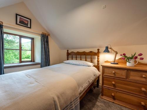 a bedroom with a bed and a dresser and a window at 4 Bed in Longtown 86497 in Llanveynoe