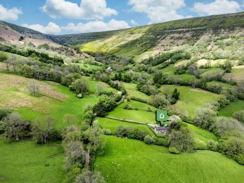 an aerial view of a green field with a house at 4 Bed in Longtown 86497 in Llanveynoe