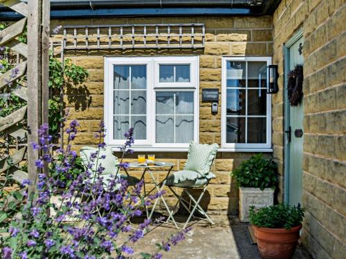 a patio with a table and chairs and a window at 1 bed property in Easingwold 84002 in Crayke