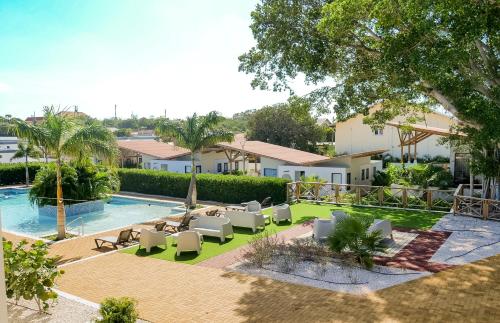 une vue sur une piscine avec des chaises longues et un complexe hôtelier dans l'établissement Malvales Resort, à Willemstad