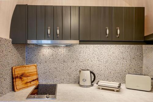 a kitchen with a counter with a laptop and a toaster at Parastia Luxury Villa Santorini - Private Jacuzzi in Éxo Goniá