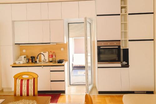 a kitchen with white cabinets and a stove top oven at Million Star Apartment in Budva