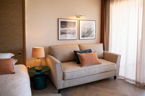 a living room with a couch and a bed at Grand Hôtel Les Flamants Roses Thalasso & Spa in Canet-en-Roussillon