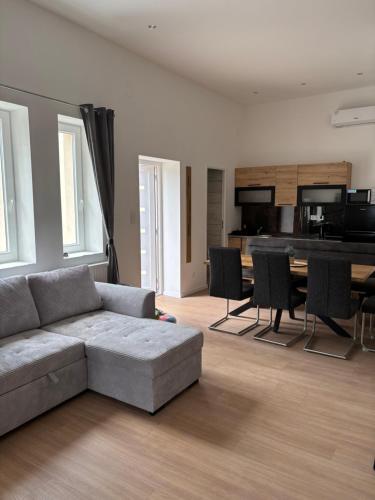 a living room with a couch and a table at Zelia Apartmanház in Siófok