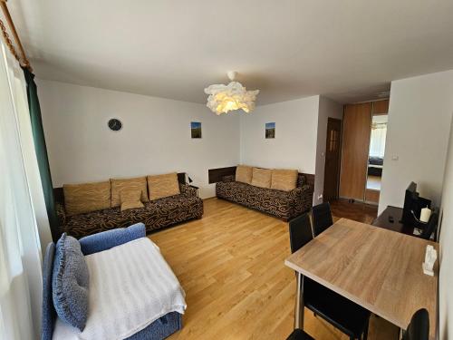 a living room with a couch and a table at Przytulny - blisko centrum in Suwałki