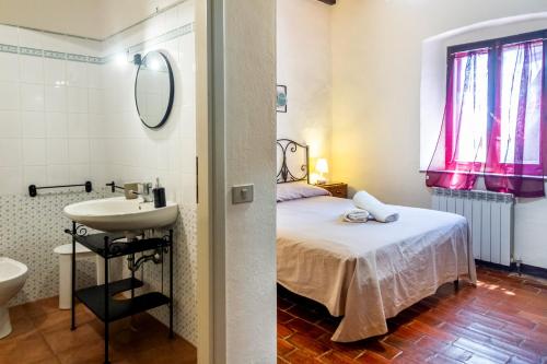 a bathroom with a bed and a sink in a room at Agriturismo La Concia in Gavorrano