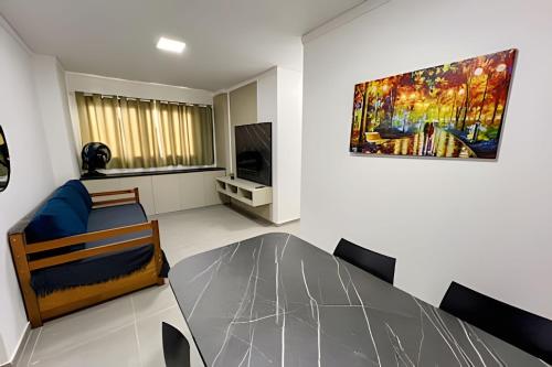 Una sala de estar con una mesa de comedor y un cuadro. en Apto central com cama hospitalar, en Londrina