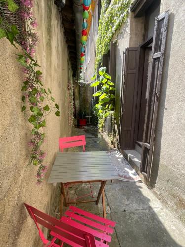 deux chaises rouges et une table en bois dans une ruelle dans l'établissement Appartement avec Patio, à Carcassonne