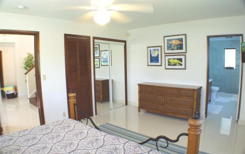 a bedroom with a bed and a dresser and a mirror at Hideaway Villa 2 Minute walk to Gracebay beach in The Bight Settlements