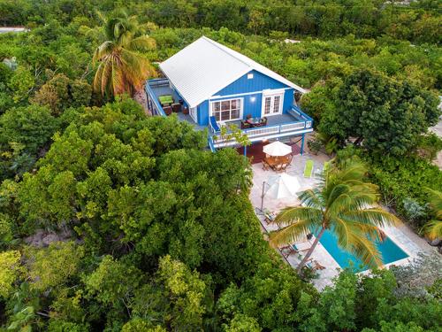 an aerial view of a blue house with a swimming pool at Hideaway Villa 2 Minute walk to Gracebay beach in The Bight Settlements
