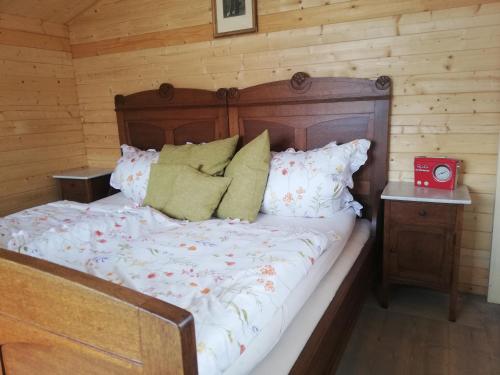 a bed in a room with a wooden wall at AlmOtel - Auf der HerziAlm 