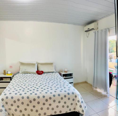 a bedroom with a bed with a polka dot bedspread at Casa próximo à praia Canasvieiras e ingleses in Florianópolis