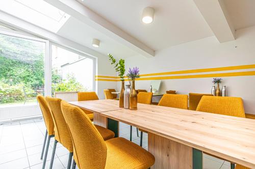 a dining room with a wooden table and yellow chairs at Hotel Astral Vienna in Vienna
