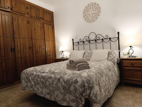 a bedroom with a bed with a black and white bedspread at Casa Ana, Fantásticas vistas a Frigiliana, el mar y la montaña in Frigiliana