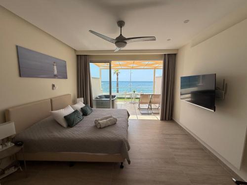 a bedroom with a bed with a view of the ocean at Harbour Lights Studio Apartments in Paphos City