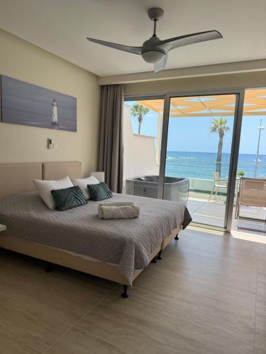a bedroom with a bed with a view of the ocean at Harbour Lights Studio Apartments in Paphos City