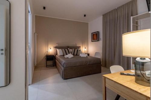 a bedroom with a bed and a desk with a lamp at Hotel Vicolo Aperta in Trapani