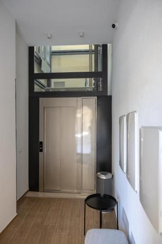 a room with a door and a table and a stool at Hotel Vicolo Aperta in Trapani