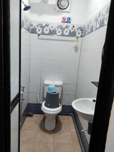 a bathroom with a toilet with a blue lid at Perhentian Najmi Hotel in Perhentian Island