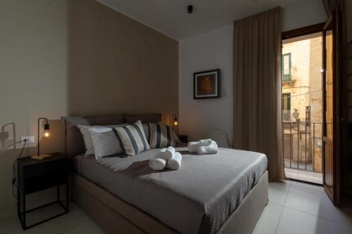 a bedroom with a bed with two stuffed animals on it at Hotel Vicolo Aperta in Trapani