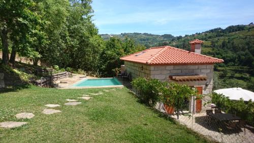 a house with a swimming pool next to a building at Quinta da Bouça - Agroturismo in Paços de Gaiolo