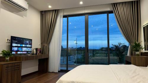 a bedroom with a bed and a large window at Happy Ocean View Villa in Tài Xá